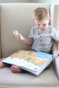 A boy reading the Discover Talking book independently by listening to the talking pen read aloud to him, so his can learn S.T.E.M. facts screen free